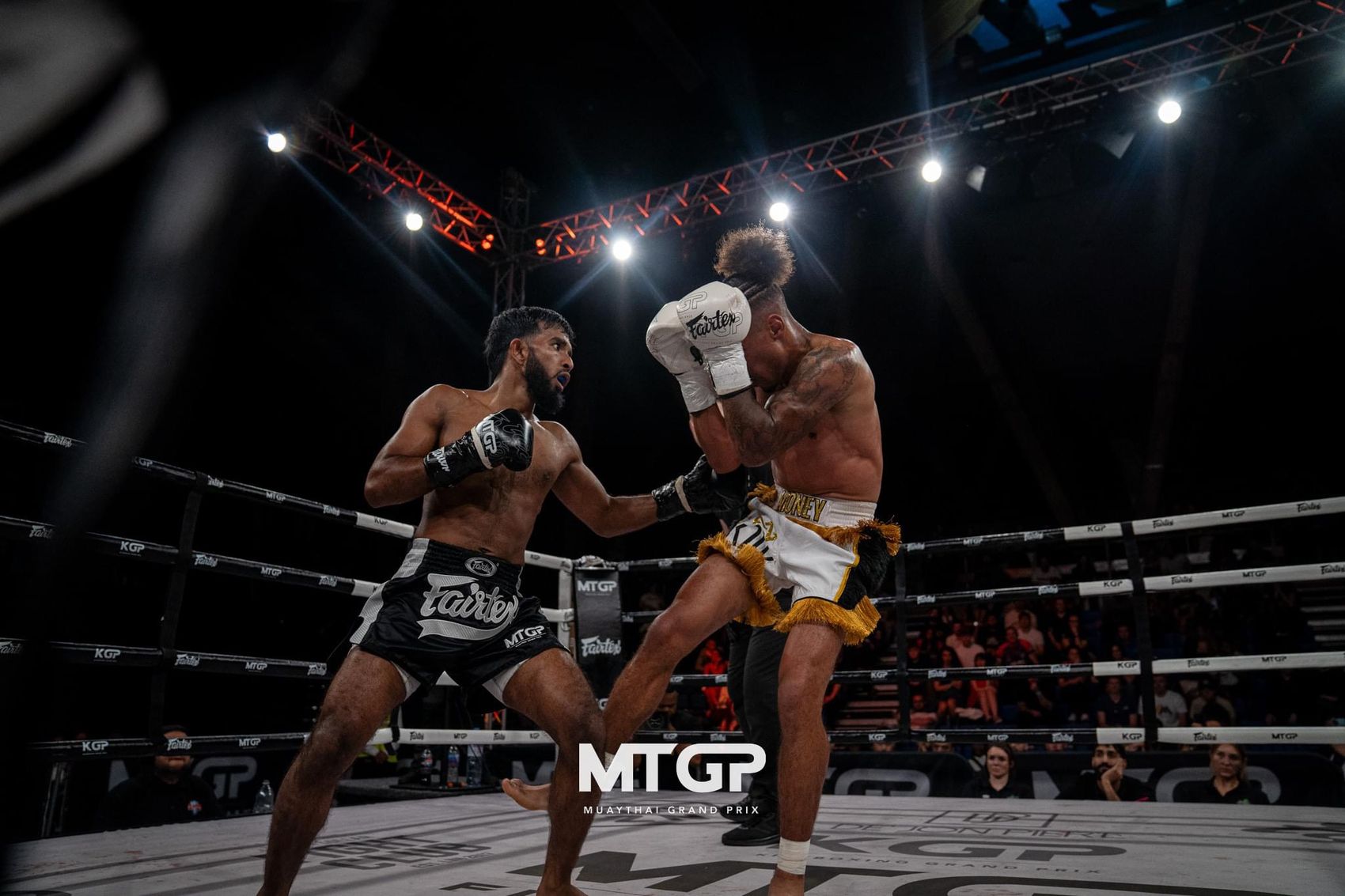 Hasib Bin Tareq mid-exchange under the lights on a professional fight card, landing a right hand.