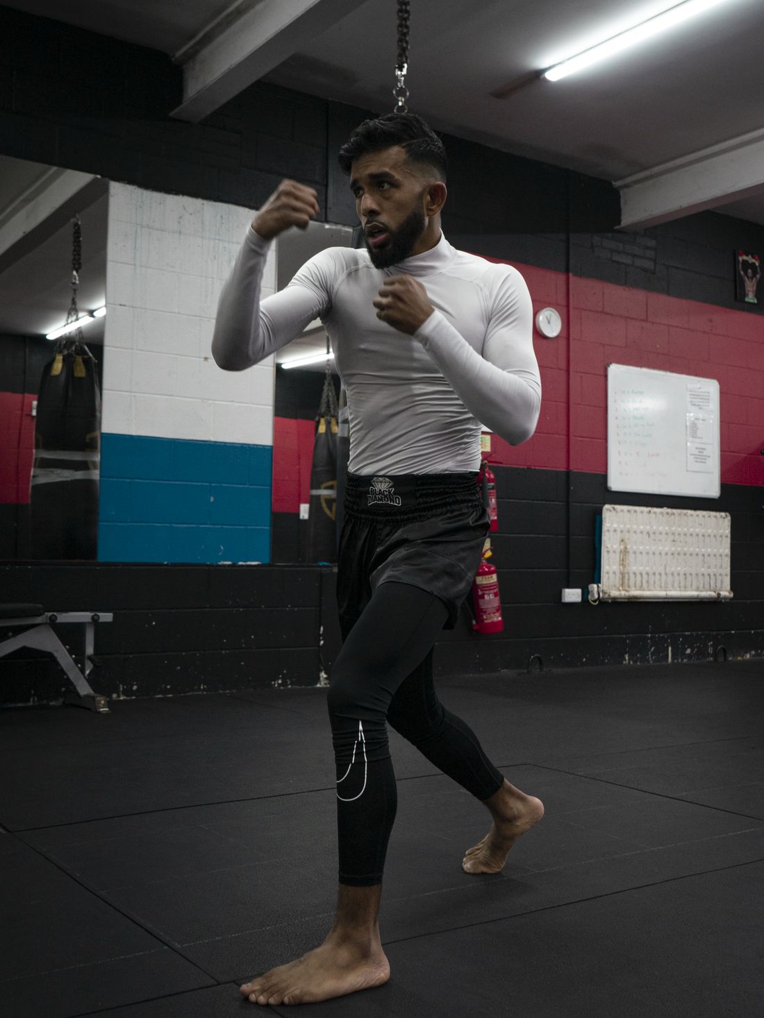 Hasib Bin Tareq shadowboxing in a white rashguard on the gym floor at Black Diamond Gym.